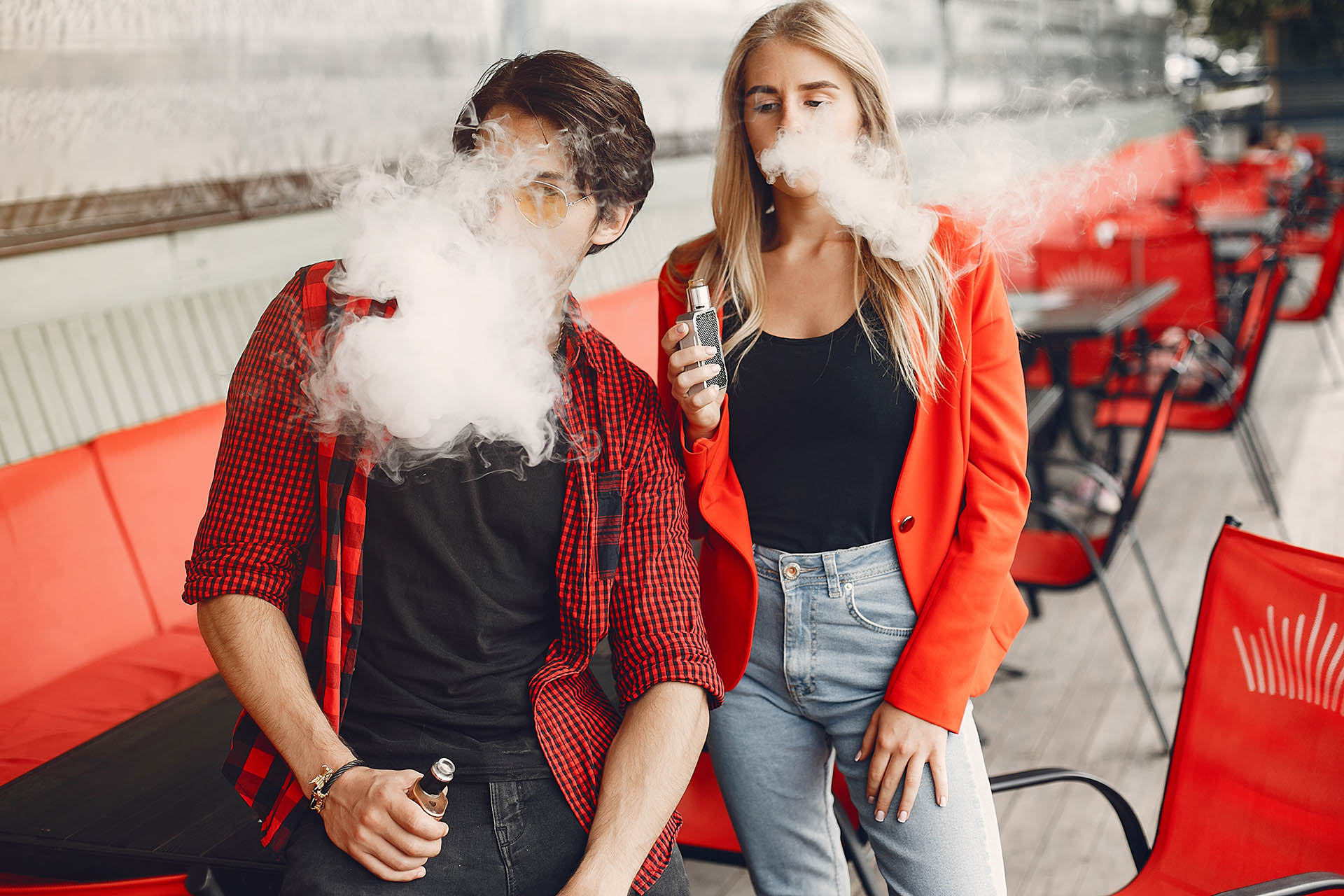 Stylish young couple with vape