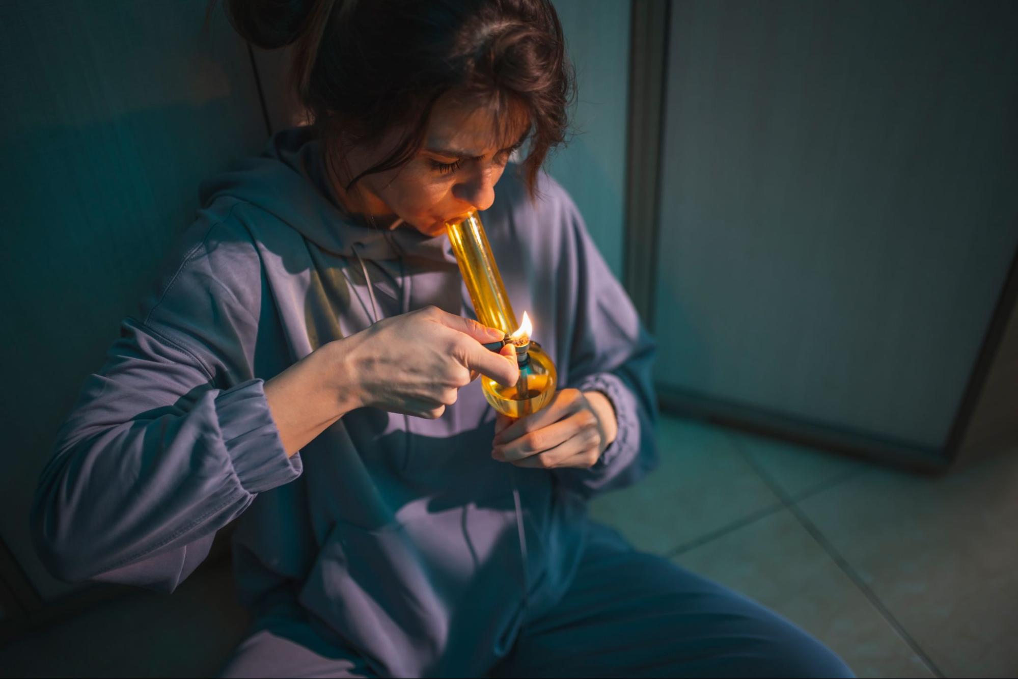 Woman using a bong to smoke weed. 