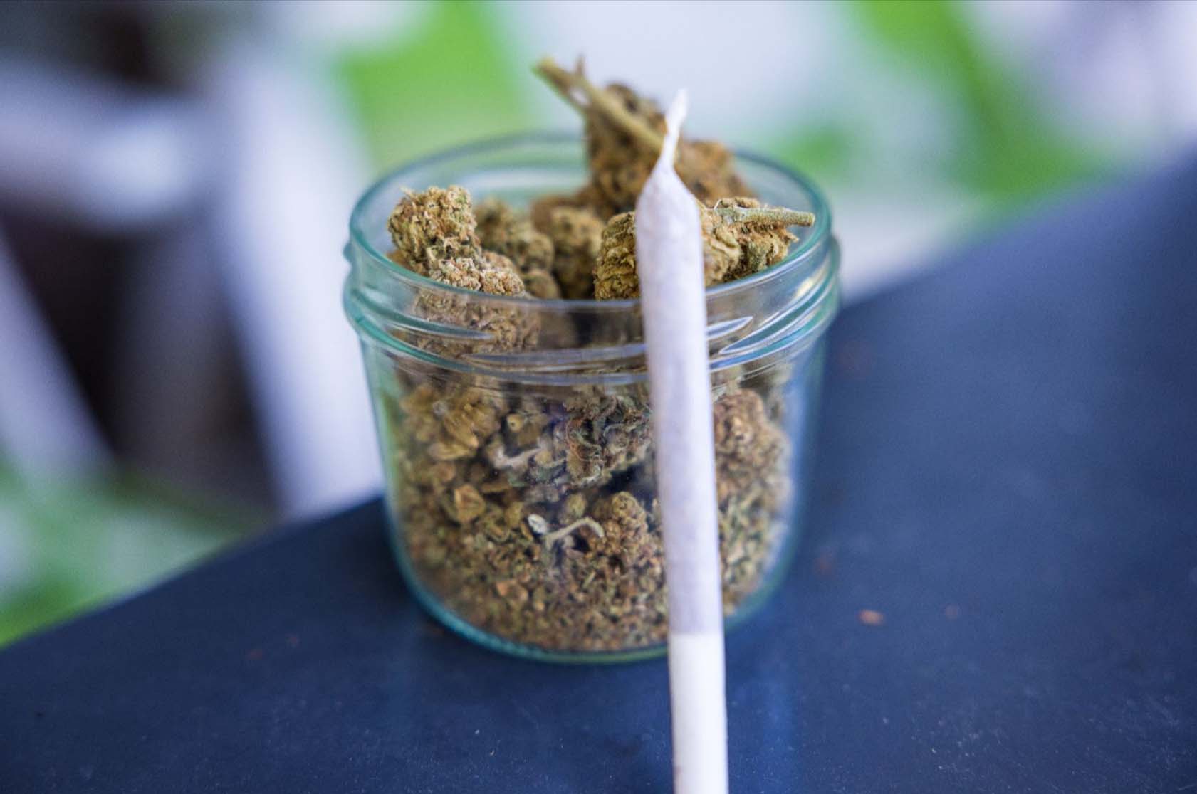 Joint beside jars of cannabis.