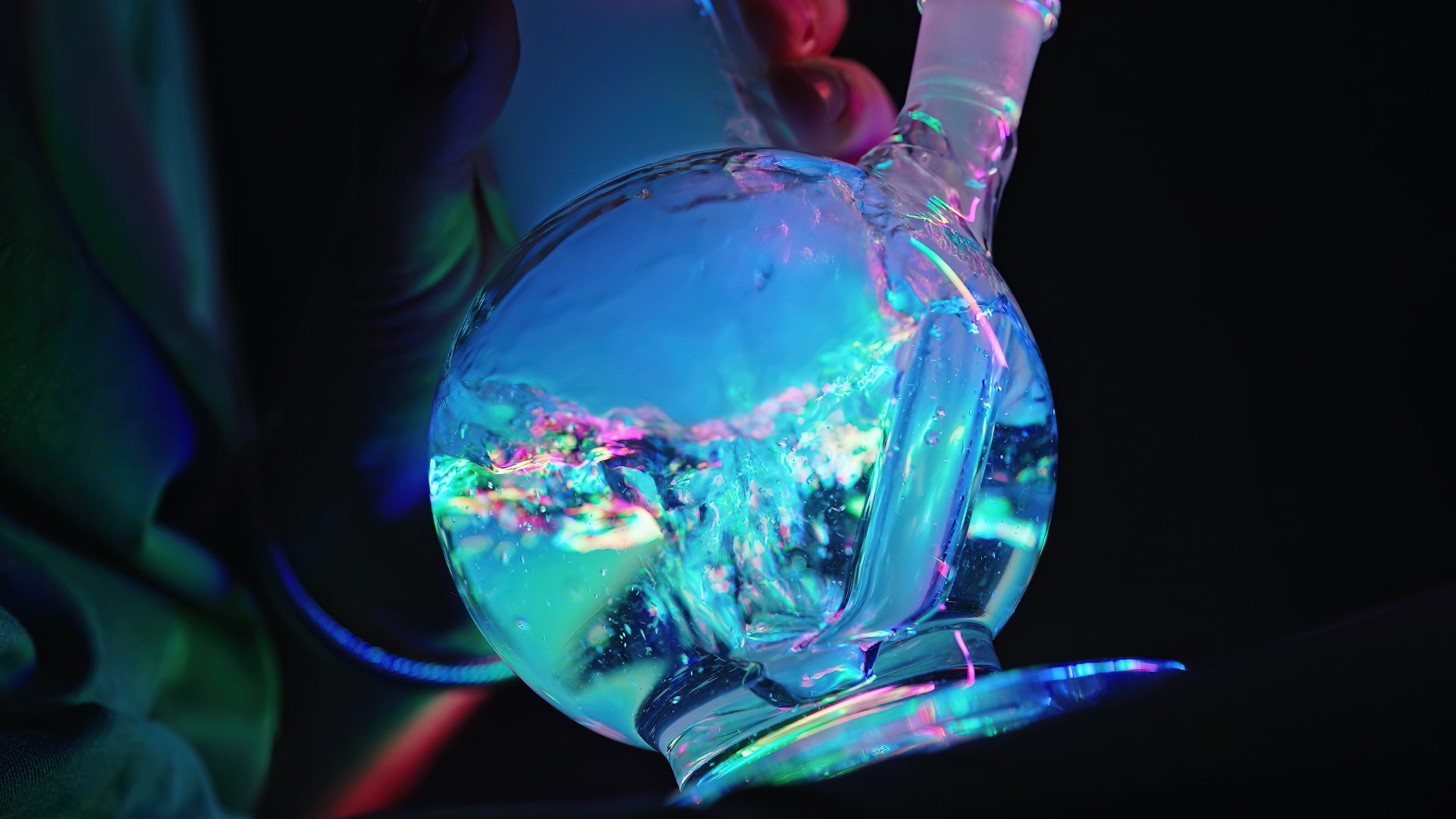 Cropped view of the base of a blue bong with bubbles forming as someone inhales smoke.