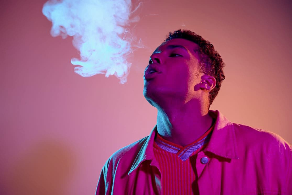 Man exhaling a cloud of smoke.