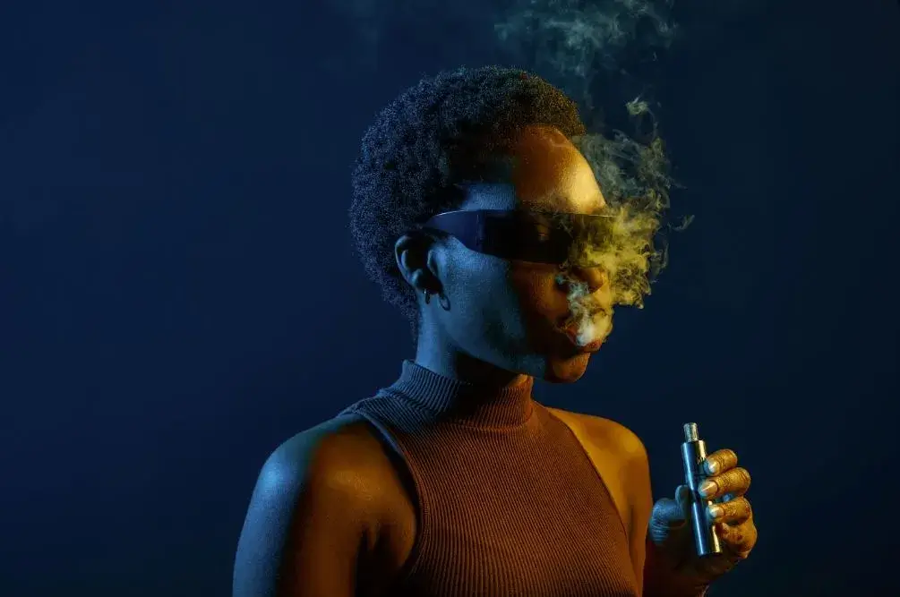 Woman in sunglasses smoking.