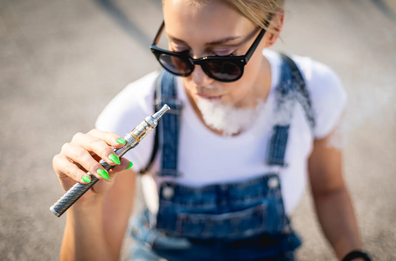 A woman vaping from her vape pen.