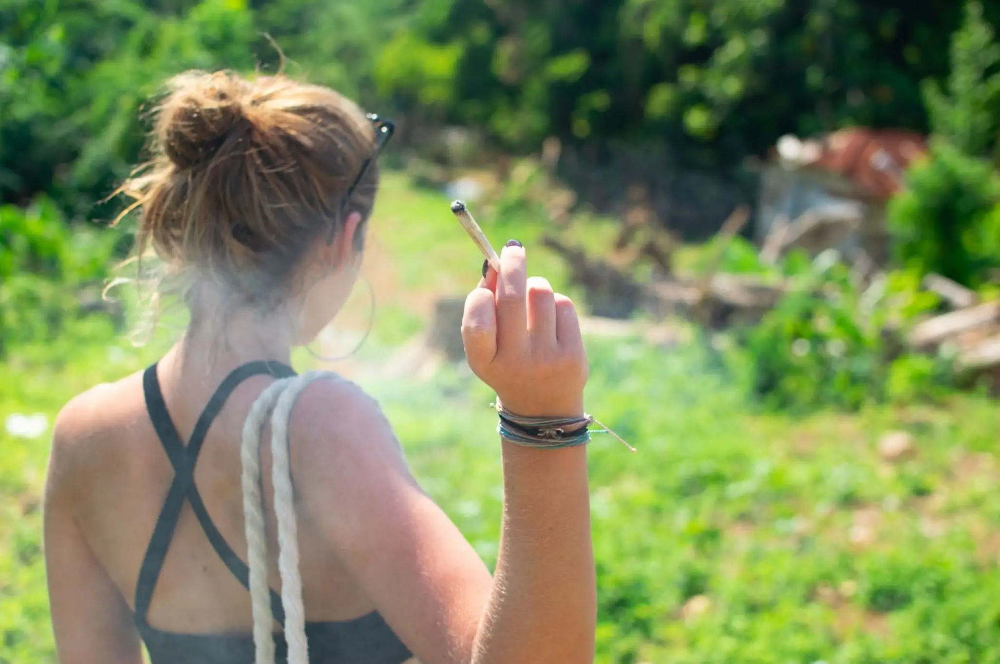 a woman holding a joint and smoking.