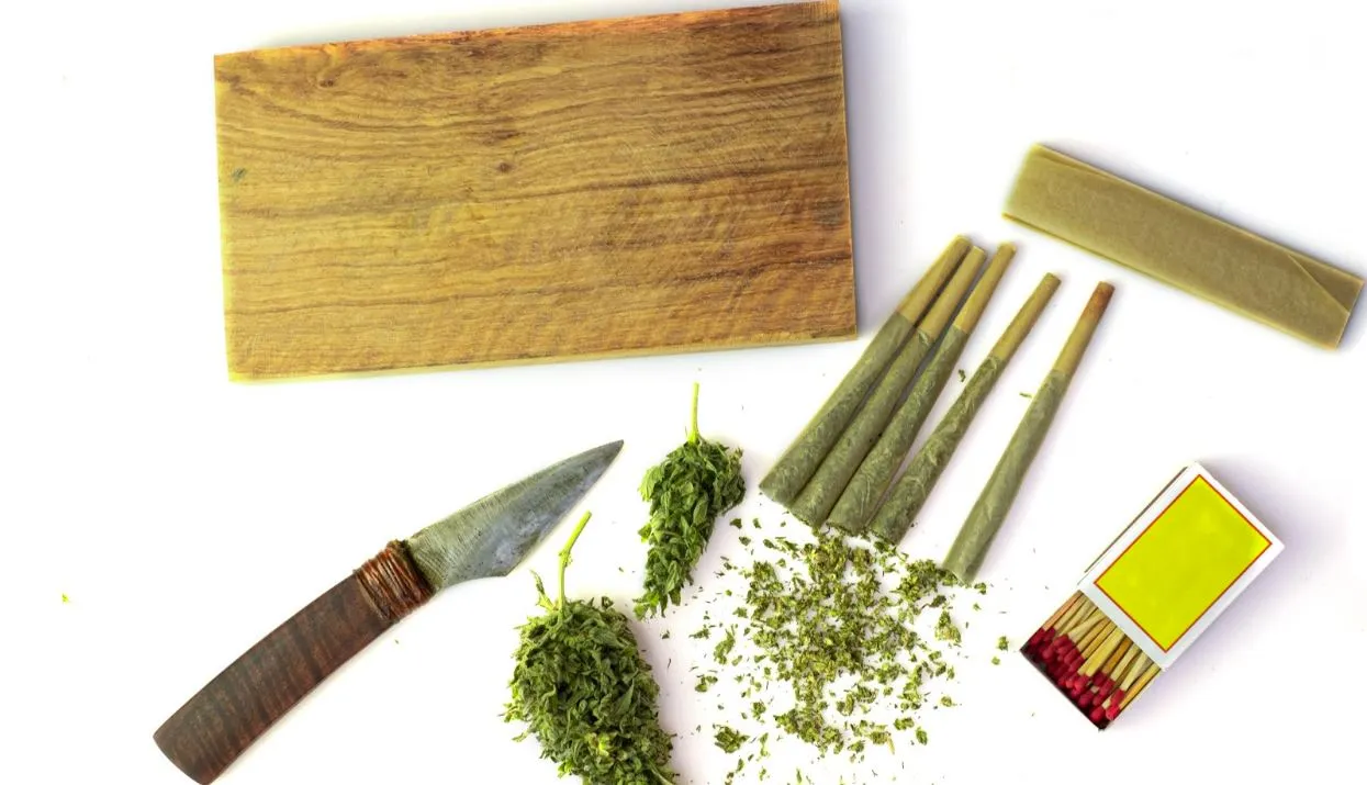 marijuana wrapped blunts matches a knife and a cutting board